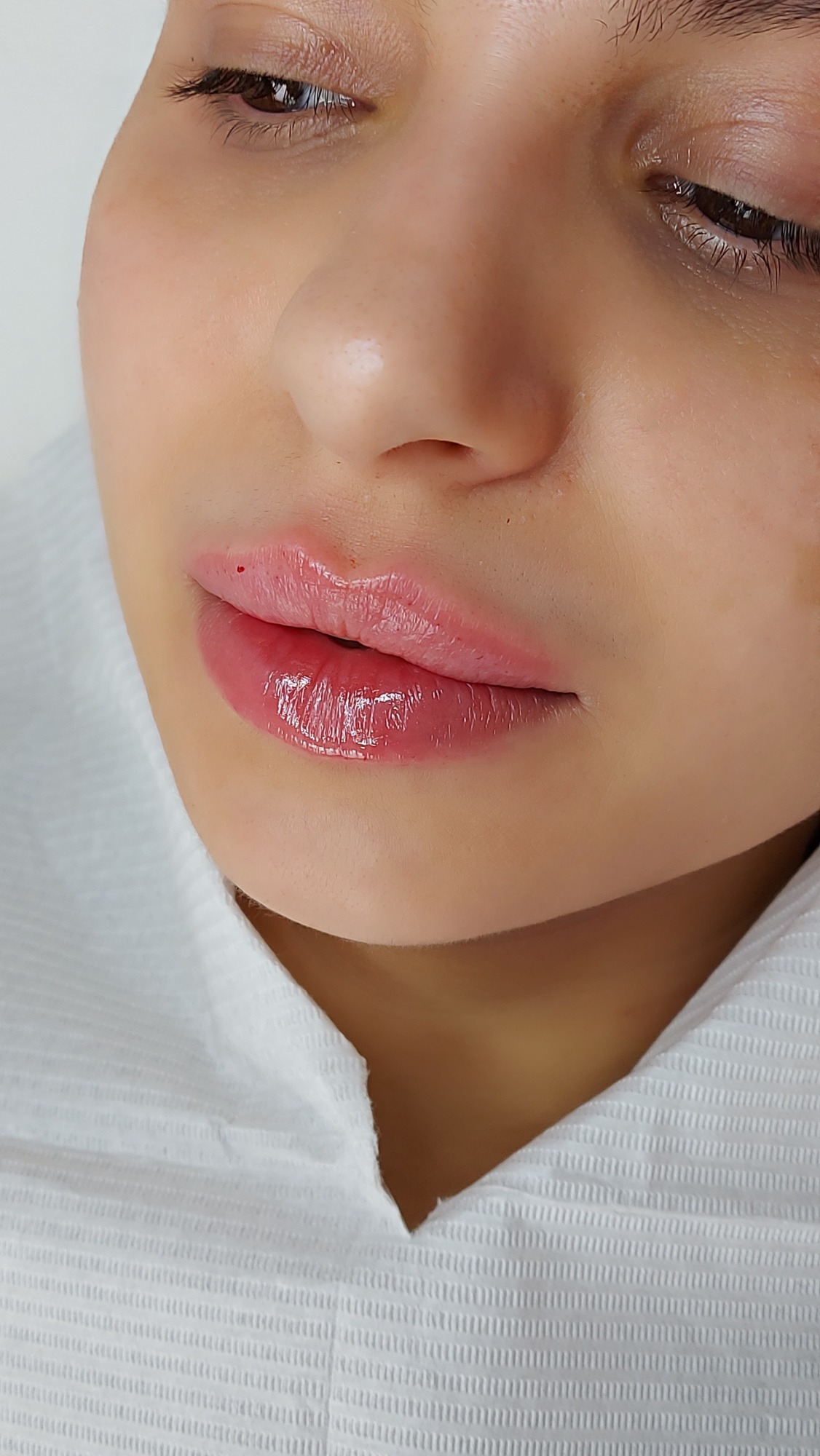Russian Lips bei Natalia Hamann Nahaufnahme eines Gesichts mit glänzenden Lippen und neutralem Hintergrund.